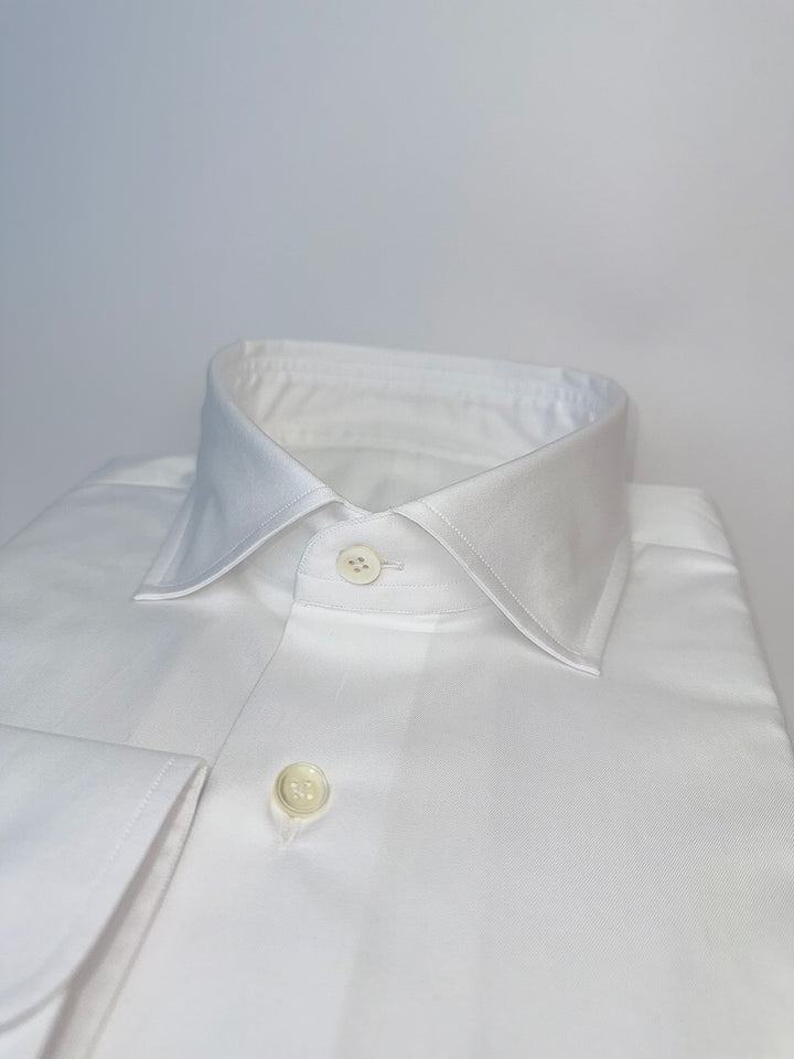 Close-up of a white shirt collar with buttons on a light gray background